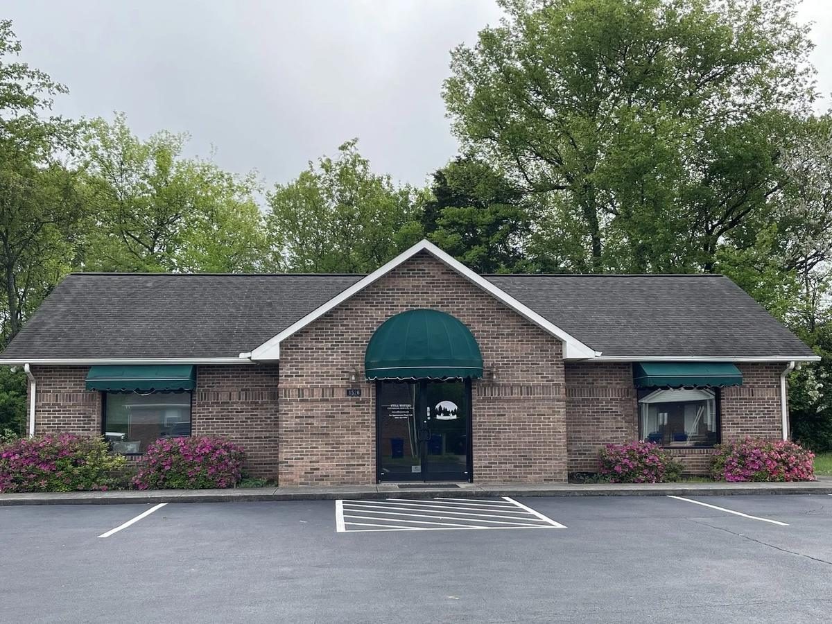 The office at 1526 Meadow Spring Dr in Jefferson City: a one-story brick building with green awnings and parking in front